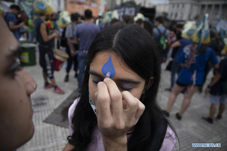 Un joven pinta una gota de agua en la frente de una mujer durante la Marcha Plurinacional por el Agua en el marco del Día Mundial del Agua frente al Congreso Nacional, en la ciudad de Buenos Aires, Argentina, el 22 de marzo de 2022. El Día Mundial del Agua se conmemora anualmente el 22 de marzo para recordar la relevancia del vital líquido. (Xinhua/Martín Zabala)