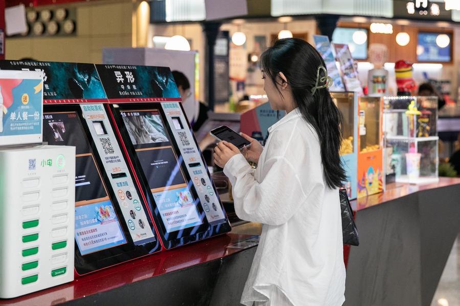 Una espectadora retira entradas en una máquina de autoservicio en un cine en Beijing, capital de China, el 21 de agosto de 2024. (Xinhua/Chu Jiayin)