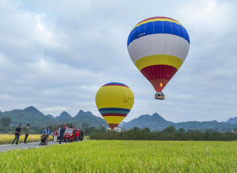 Imagen tomada con un dron el 6 de octubre de 2024 de turistas tomando globos aerostáticos para hacer recorridos turísticos, en el poblado de Wanjing del distrito de Ningyuan, en la provincia de Hunan, en el centro de China. (Xinhua/Jiang Keqing) 