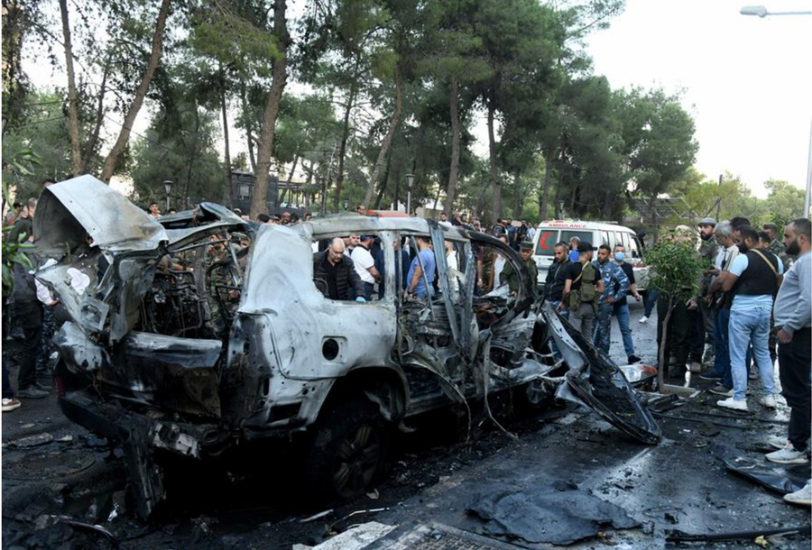 Personas se reúnen alrededor de los restos de un vehículo alcanzado por un ataque aéreo israelí, en el barrio Mazzeh de Damasco, Siria, el 21 de octubre de 2024. (Xinhua/Ammar Safarjalani)