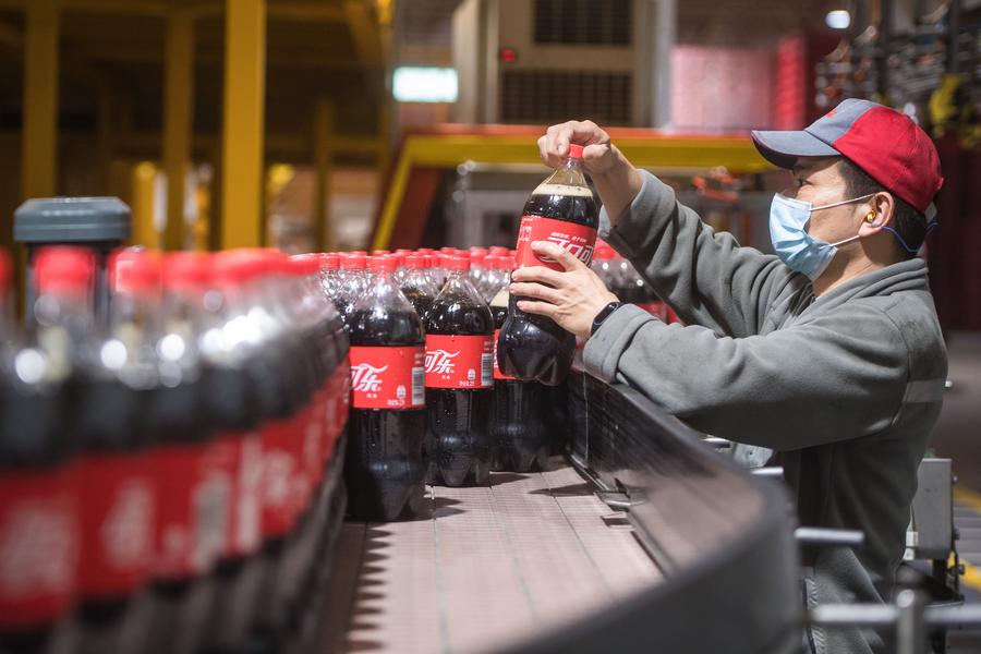 Un hombre trabaja en una línea de producción de la empresa Swire Coca-Cola Beverages Hubei Limited, en Wuhan, provincia de Hubei, en el centro de China, el 24 de marzo de 2020. (Xinhua/Xiao Yijiu) 