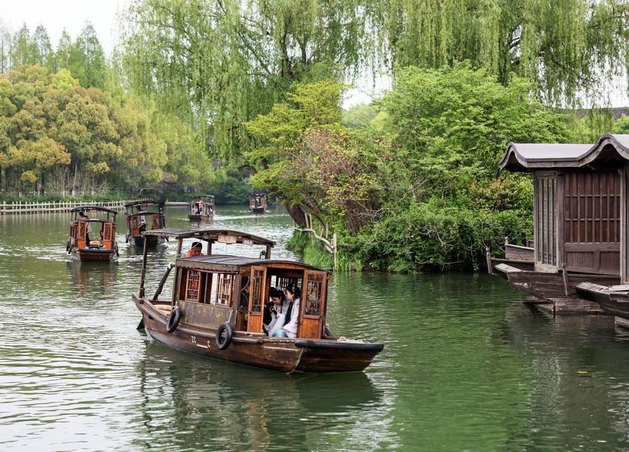 Turistas pasean en botes de remo por el poblado ribere?o de Wuzhen, en la ciudad de Jiaxing, provincia oriental china de Zhejiang, el 11 de abril de 2024. (Xinhua/Lan Hongguang)