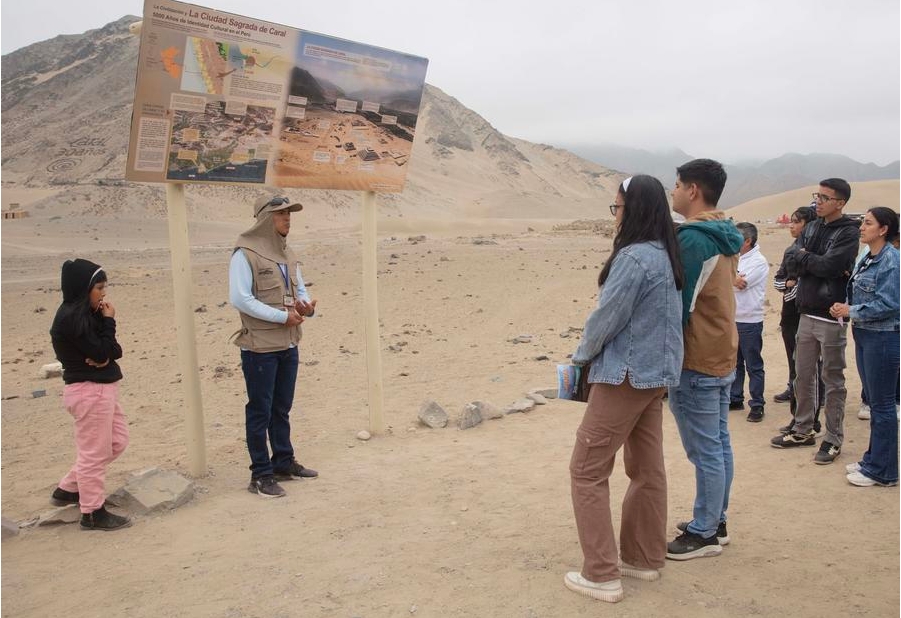 Un trabajador informa a los visitantes en la Zona Arqueológica Caral en el marco de los 30 a?os de investigaciones de la civilización Caral, en Supe, en la provincia de Barranca, Perú, el 26 de octubre de 2024. Las tres décadas que este 2024 cumplen la arqueóloga peruana Ruth Shady y su equipo investigando la milenaria civilización Caral, les ha permitido ratificar que se trató de una sociedad que se guió por "conocimientos y valores" para su desarrollo. (Xinhua/Mariana Bazo)