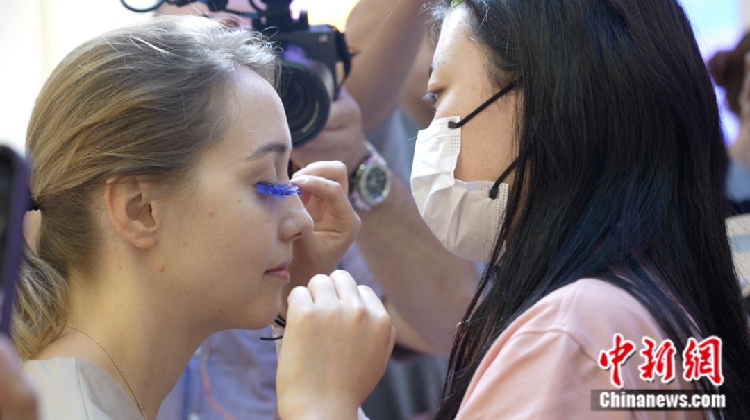 Un visitante extranjero se prueba pesta?as postizas en Pingdu, una ciudad a nivel de condado en la provincia oriental china de Shandong conocida como "la capital china de las pesta?as postizas". (Foto cortesía del departamento de publicidad del comité municipal de Pingdu del Partido Comunista de China)