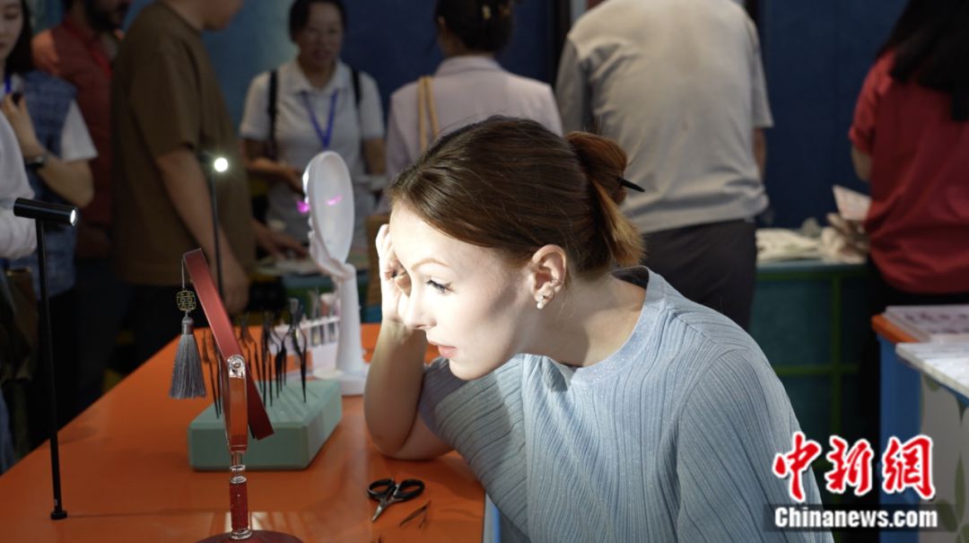 Un visitante extranjero se prueba pesta?as postizas en Pingdu, una ciudad a nivel de condado en la provincia oriental china de Shandong conocida como "la capital de las pesta?as postizas de China". (Foto cortesía del Departamento de Publicidad del Comité Municipal del Partido Comunista de China en Pingdu)